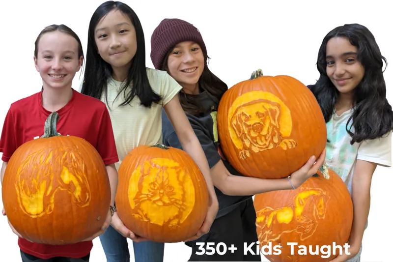 Four kids proudly holding carved pumpkins